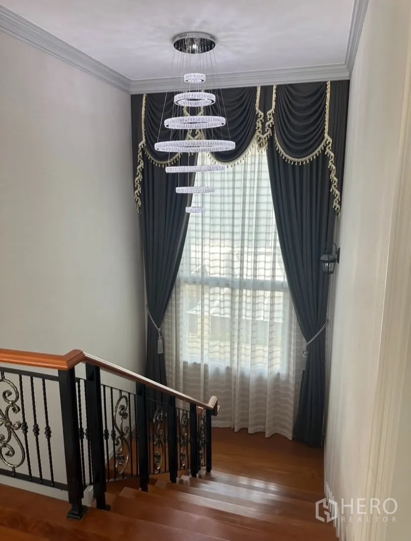 บ้านเดี่ยว for rent or sale in Prawet, Bangkok - บันไดไม้ขัดเงาพร้อมราวเหล็กดัดลายและโคมไฟทรงวงแหวนสมัยใหม่