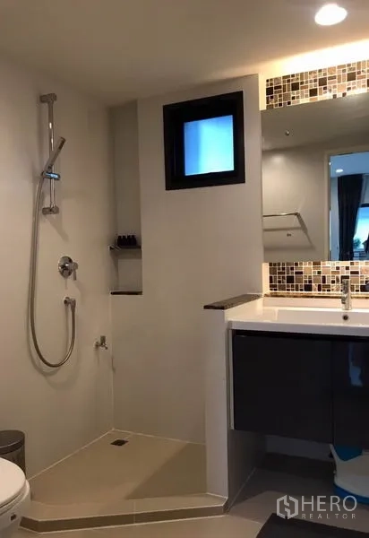 Detached House for rent in Bang Kapi, Bangkok - Contemporary bathroom with walk-in shower, vanity and mosaic-lit mirror.
