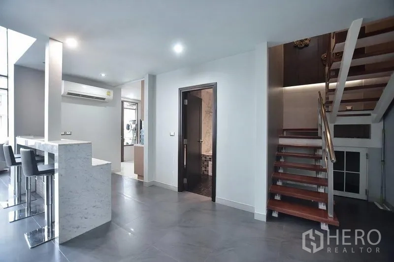 คอนโด ให้เช่าในKhlong Toei, Bangkok - เคาน์เตอร์บาร์หินอ่อนพร้อมสตูล ใกล้โถงทางเดินและบันไดไม้ขึ้นชั้นบน