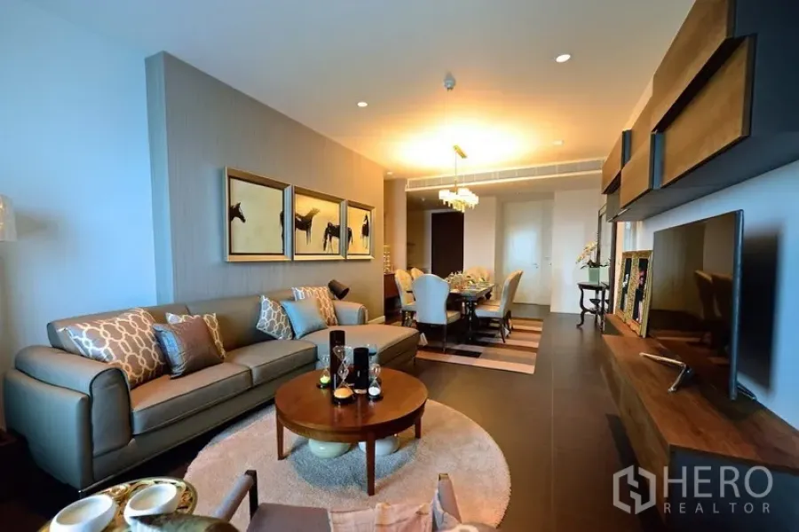 Condominium for rent in Pathum Wan, Bangkok - Elegant living room with sofa set, wall art, TV console and dining area in a luxury Bangkok condo.