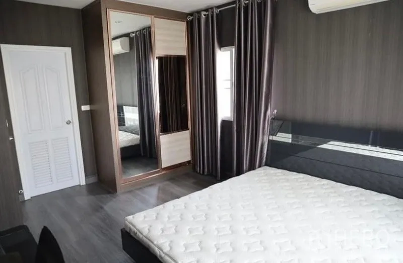 Detached House for rent in Suan Luang, Bangkok - Master bedroom angle showing mirrored wardrobe, bedside panel and air-conditioning.