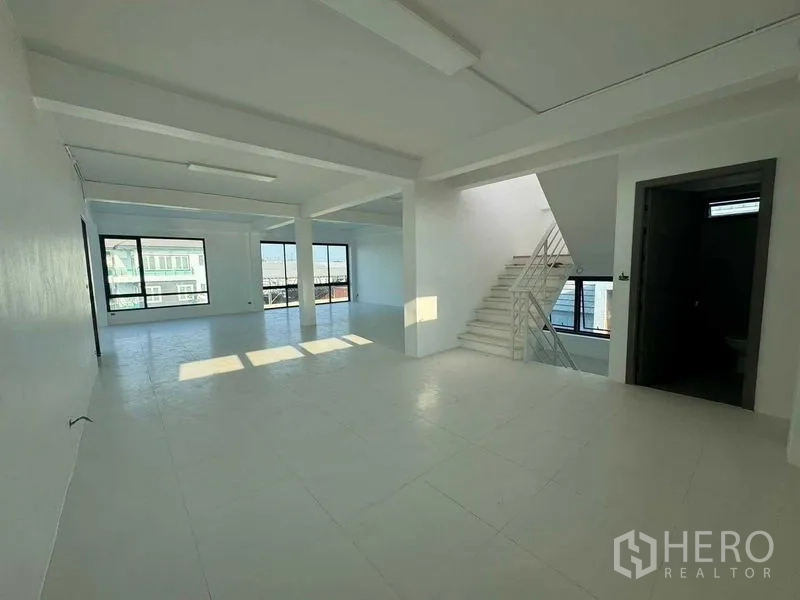 Home Office for rent in Don Mueang, Bangkok - Open upper floor beside a staircase, bright with natural light from large windows.