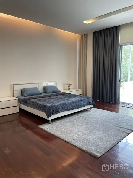 ทาวน์เฮาส์ ให้เช่าหรือขายในChatuchak, Bangkok - ห้องนอนมาสเตอร์กว้าง มีพรมขนาดใหญ่ โต๊ะข้าง และทางออกสู่ระเบียง