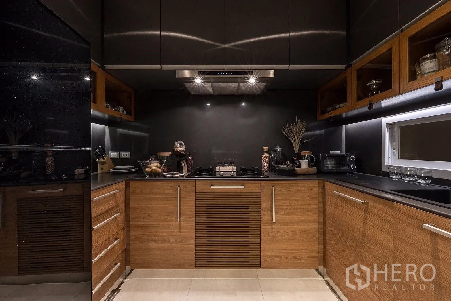 联排别墅 for sale in Suan Luang, Bangkok - 现代U形厨房，木质橱柜、黑色台面与抽油烟机。