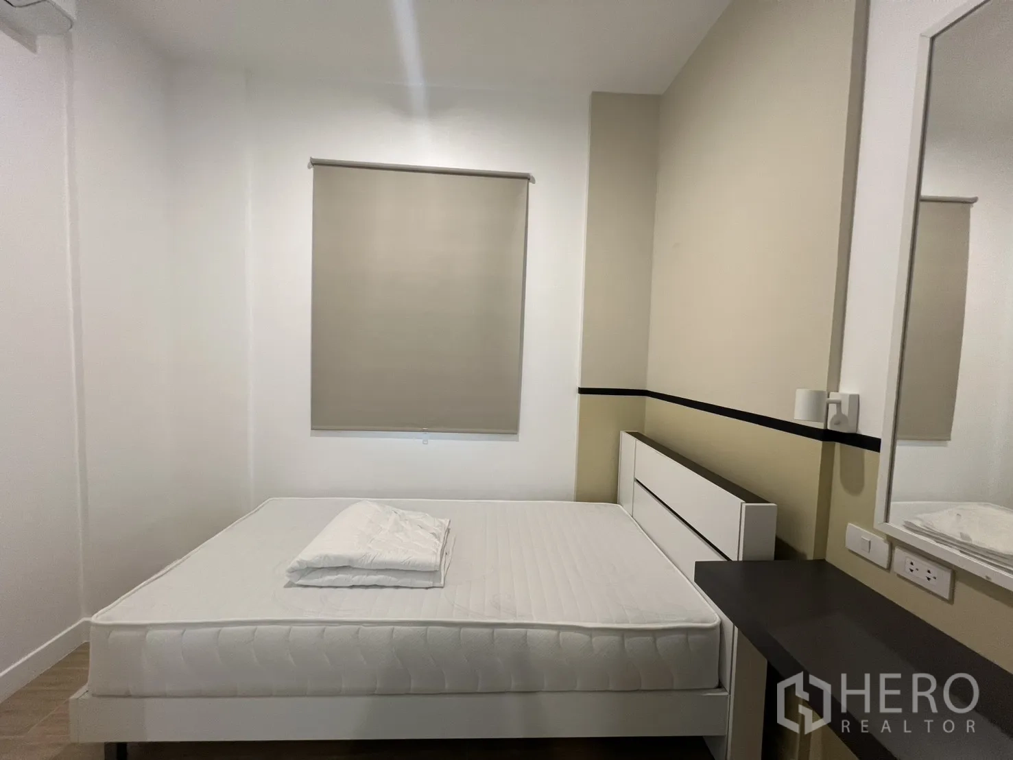 Condominium for rent in Bang Kapi, Bangkok - Spacious master bedroom with a large bed and doorway to the ensuite bathroom.