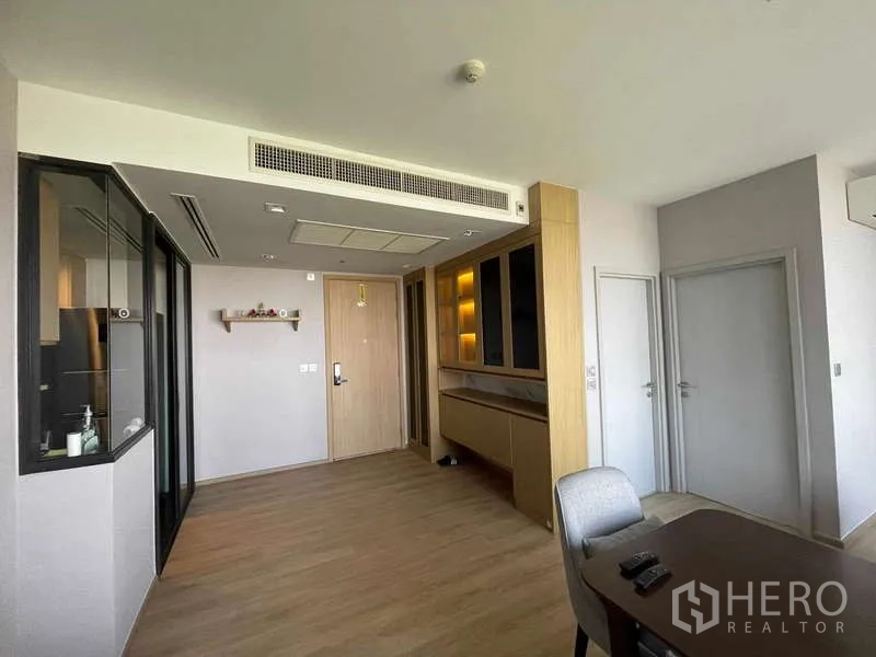 公寓 出租 - 入口与餐区，带暖光内置柜，旁连玻璃厨房。