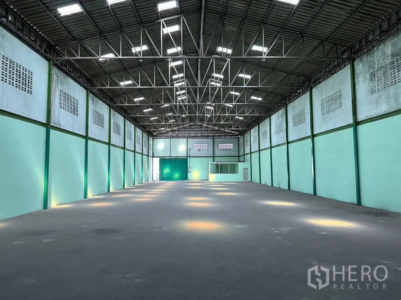Factory for rent in Bang Bo, Samut Prakan - Central view of column-free warehouse space with high roof, lighting, and wall vents.