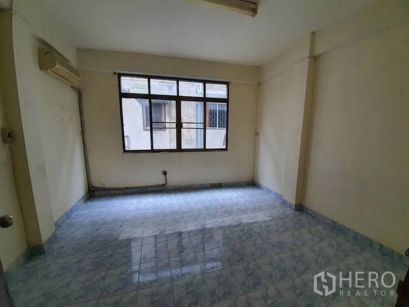 Shophouse for rent in Bang Rak, Bangkok - Mid-size tiled room with a window facing the neighboring building.
