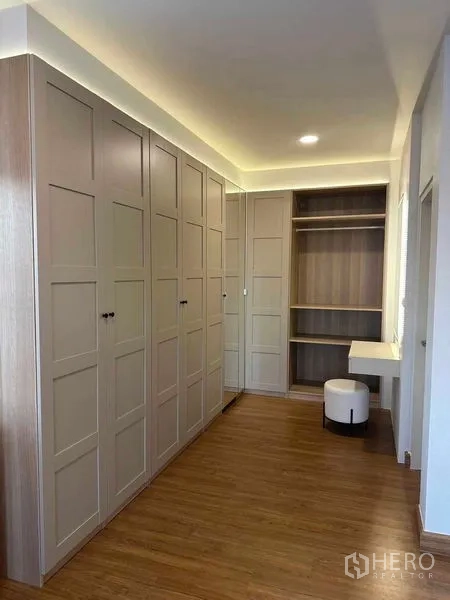Detached House for rent in Bang Phli, Samut Prakan - Walk-in closet with built-in wardrobes, open shelving and a vanity with stool under warm lighting.