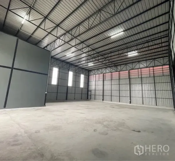 คลังสินค้า ให้เช่าในLam Luk Ka, Pathum Thani - พื้นที่เก็บของภายในเพดานสูง โครงหลังคาเหล็ก แผ่นรับแสงธรรมชาติ และพื้นคอนกรีตเรียบ.