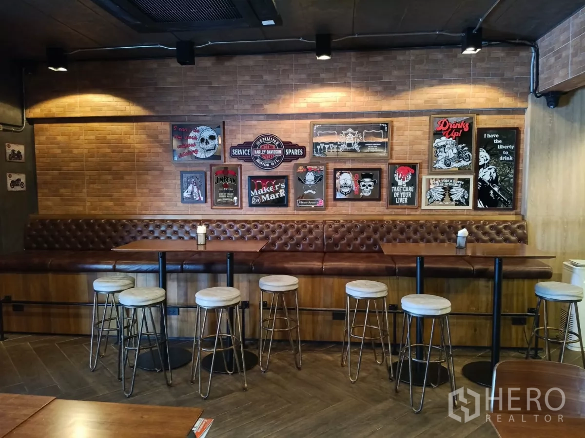 Retail Space for rent - Seating area with high tables, stools and framed artwork above a leather banquette.