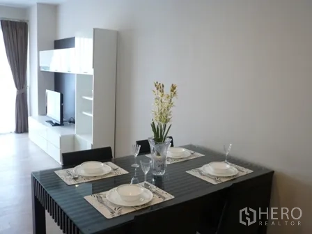 公寓 出租在Watthana, Bangkok - 四人玻璃餐桌，采光充足的起居空间。