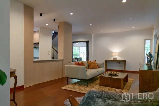 บ้าน ให้เช่าในWatthana, Bangkok - โถงนั่งเล่นโอเพ่นแปลน พื้นไม้ เคาน์เตอร์บิลท์อิน และหน้าต่างบานใหญ่