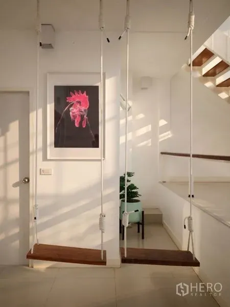 ทาวน์เฮาส์ ให้เช่าในKhlong Toei, Bangkok - โถงทางเดินสว่างพร้อมชิงช้าในบ้าน บันได และงานศิลป์ในทาวน์เฮ้าส์สไตล์โมเดิร์น