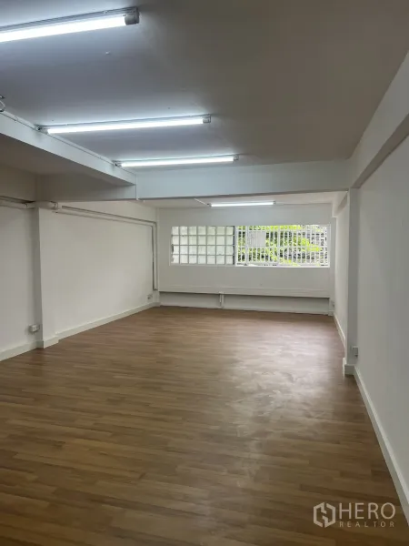 店屋 出租在Watthana, Bangkok - 采光明亮的楼层，白墙、木纹地板与日光灯，玻璃砖窗