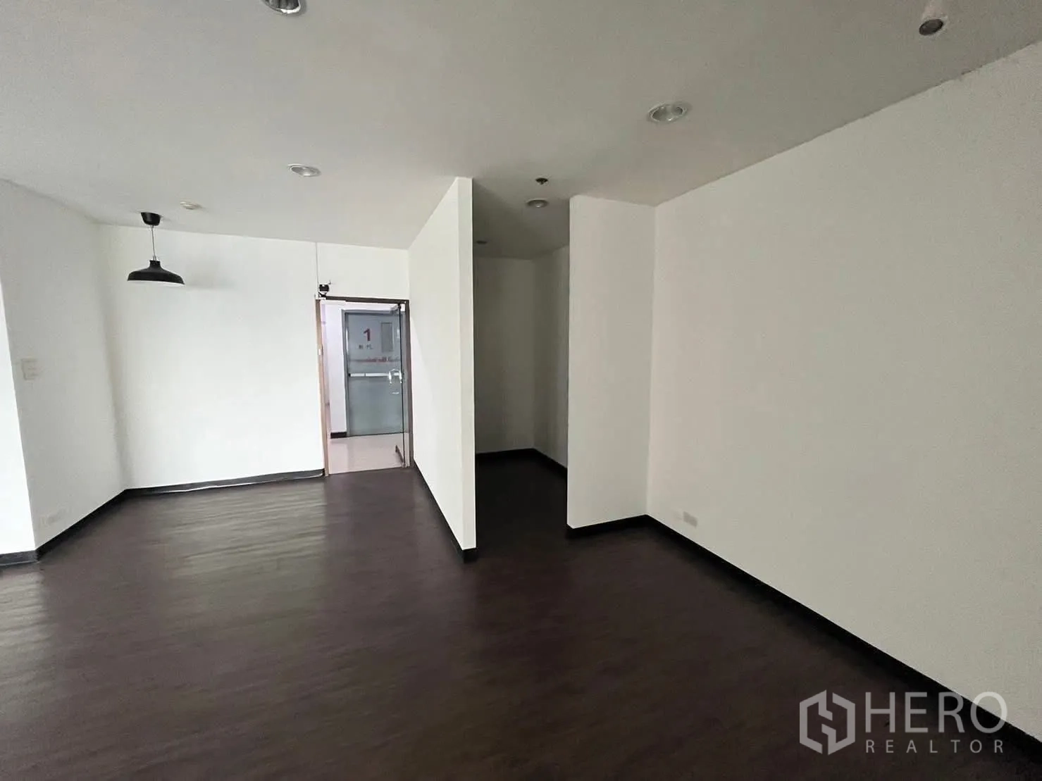 ออฟฟิศ for rent in Watthana, Bangkok - มุมทำงานพร้อมโคมแขวน ผนังสีขาว และทางออกสู่โถงทางเดิน.