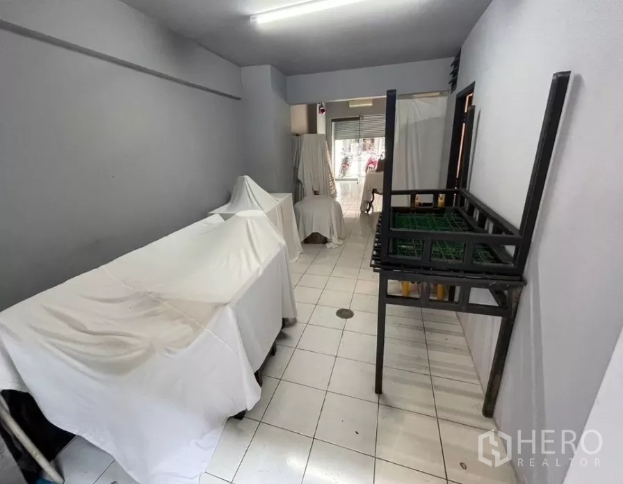 อาคารพาณิชย์ ให้เช่าในWatthana, Bangkok - ห้องด้านหลังแนวยาว พื้นกระเบื้องสีขาว ไฟฟลูออเรสเซนต์ มองไปทางถนน