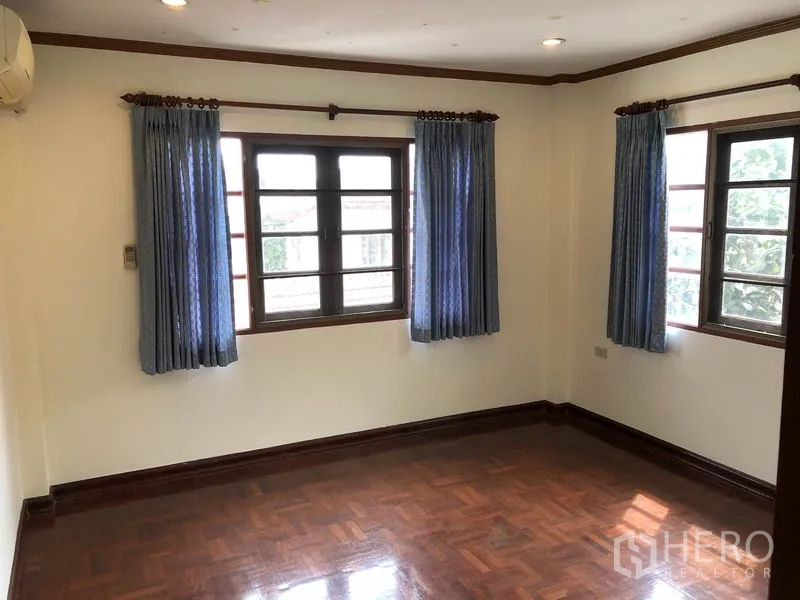 独立式住宅 出租 - 转角卧室，三面开窗，蓝色窗帘与木质线条。