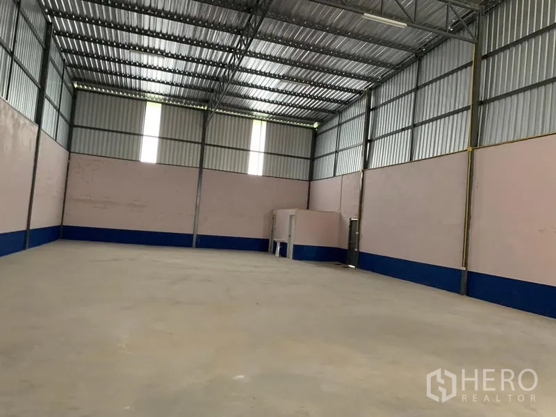 货栈 出租在Saphan Sung, Bangkok - 无柱仓库内部视角，通风窗、混凝土地坪，后方设有小型内置房间。