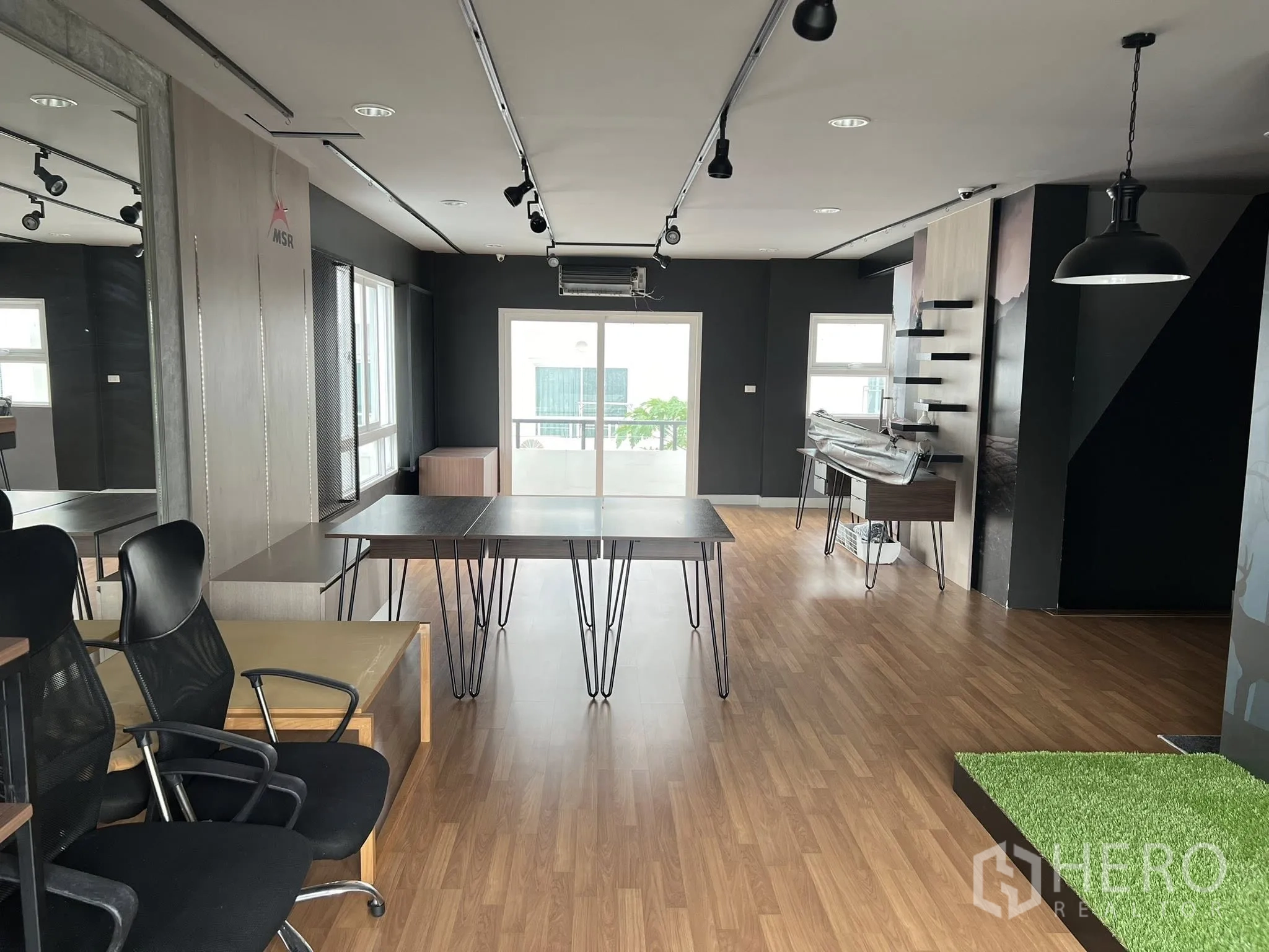 Detached House for rent or sale in Don Mueang, Bangkok - Spacious office floor with tables, pendant lights and sliding balcony doors.