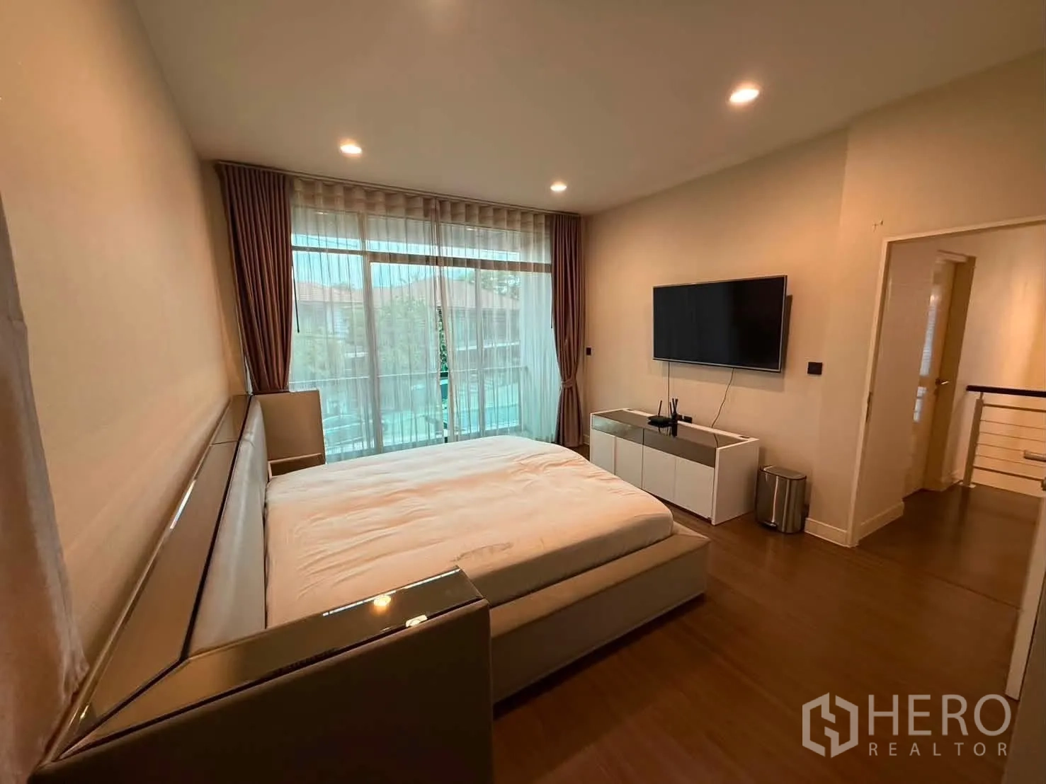 独栋房屋 for rent in Bang Kapi, Bangkok - 卧室配电视柜与大幅落地玻璃门窗。
