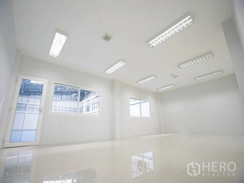 工厂 出租在Bang Bo, Samut Prakan - 明亮的办公室，白色墙面与瓷砖地面，荧光灯照明，窗户可眺望生产车间