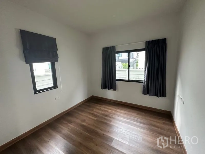 Detached House for sale in Khlong Sam Wa, Bangkok - Ground-floor bedroom with wood-style flooring and two windows