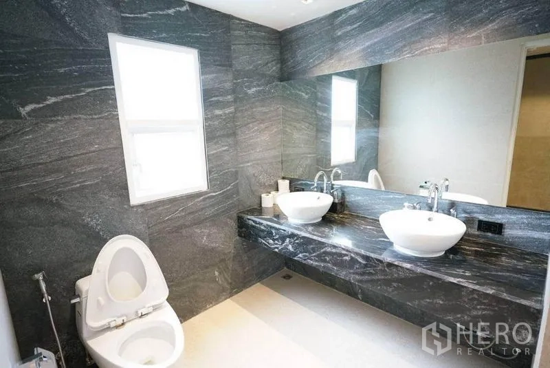 คอนโด ให้เช่าหรือขายในBang Na, Bangkok - ห้องน้ำผนังหินอ่อนสีเข้ม เคาน์เตอร์ยาว อ่างล้างหน้าคู่ และกระจกบานใหญ่
