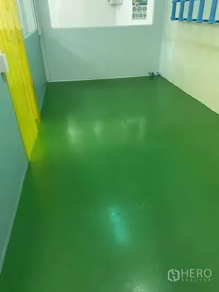 Factory for rent or sale in Bang Yai, Nonthaburi - Hygienic prep area with green epoxy flooring beside a yellow PVC curtain.