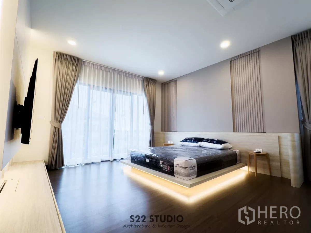 Detached House for rent in Bang Phli, Samut Prakan - Master bedroom with underlit platform bed, floor-to-ceiling windows and soft cove lighting.