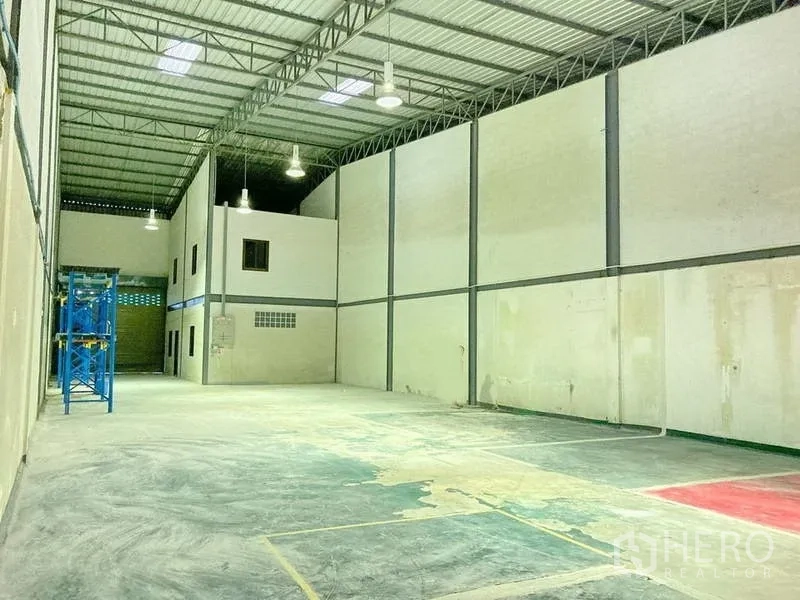 工厂 出租在Samut Prakan - 大型厂房大厅，挑高钢屋顶、吊灯与开阔生产空间