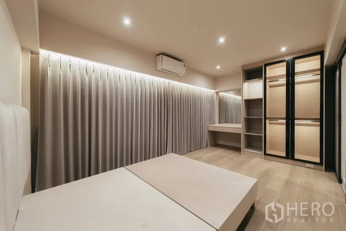 联排别墅 出租在Watthana, Bangkok - 卧室配内置衣柜、更衣区和长帘。