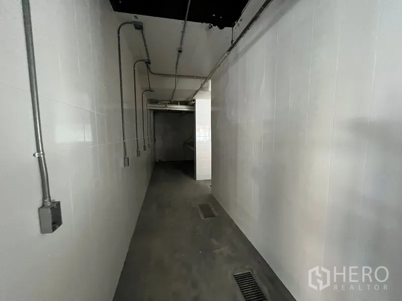 零售空间 出租在Watthana, Bangkok - 铺内长走廊，瓷砖墙与地面排水沟，便于通风排水。