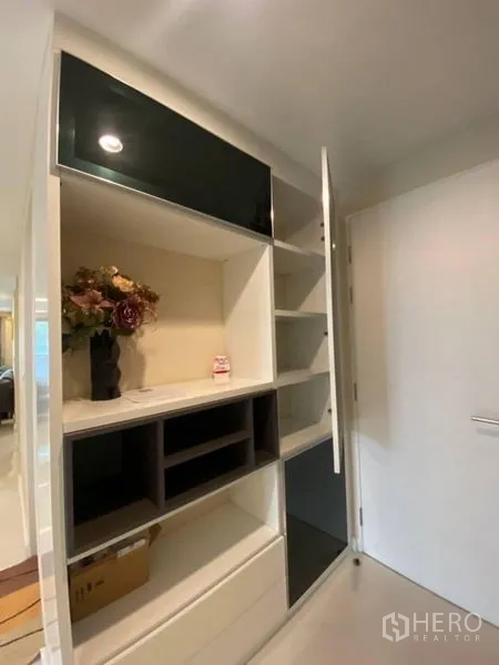 Condominium for rent in Watthana, Bangkok - Close-up of built-in storage unit with open shelves and cabinets near the entry.