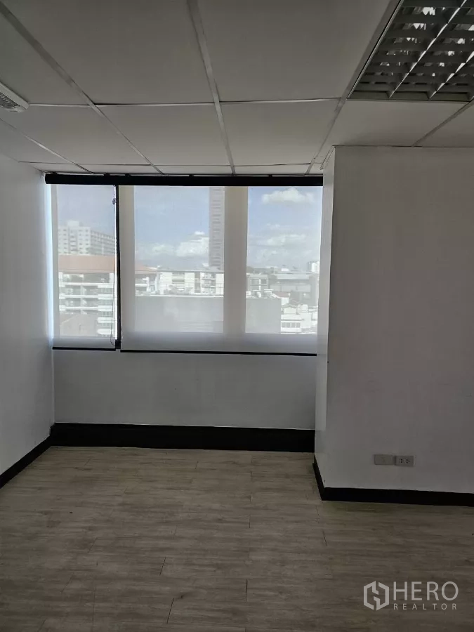 办公空间 出租在Watthana, Bangkok - 紧凑办公房，双扇高窗、半透卷帘与浅色木纹地板。