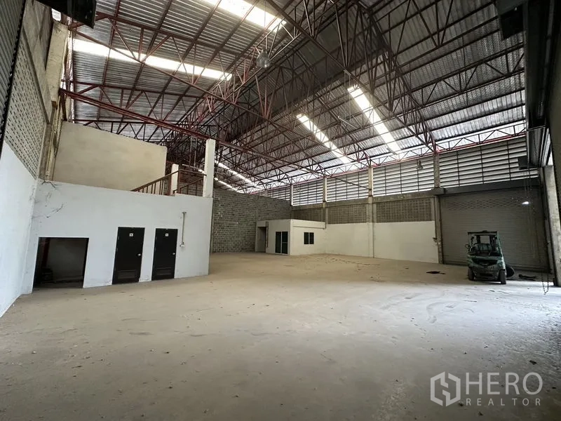 货栈 出租在Khlong Sam Wa, Bangkok - 内部视角含多扇门、夹层楼梯、通风墙体与大型卷闸门