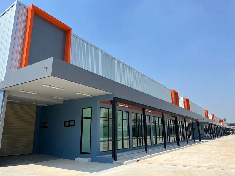 Warehouse for rent in Bang Phli, Samut Prakan - Close-up of unit entrance with glass doors, orange trim and covered loading area