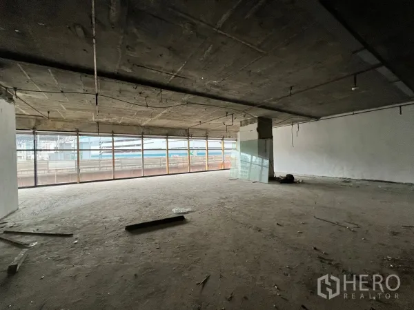 零售空间 出租 - 开放式毛坯商铺，裸露混凝土天花与整面落地窗，采光佳并可见城市景观，便于自定义装修。