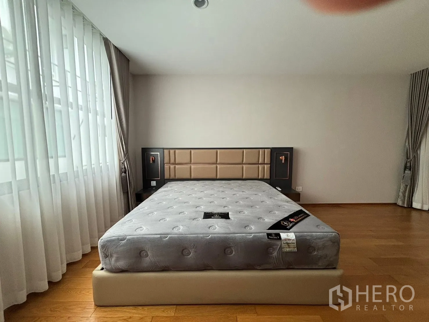 Townhouse for rent in Saphan Sung, Bangkok - Bright bedroom with a bed and sheer floor-to-ceiling curtains.