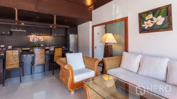 Detached House for sale in Hua Hin, Prachuap Khiri Khan - Open-plan living room with rattan sofa, breakfast bar and modern fitted kitchen.