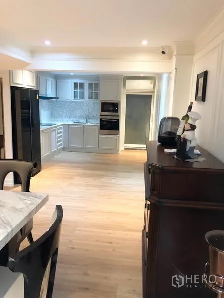 Shophouse for rent or sale in Chatuchak, Bangkok - Bright open kitchen with white cabinetry, stone backsplash and built-in ovens.