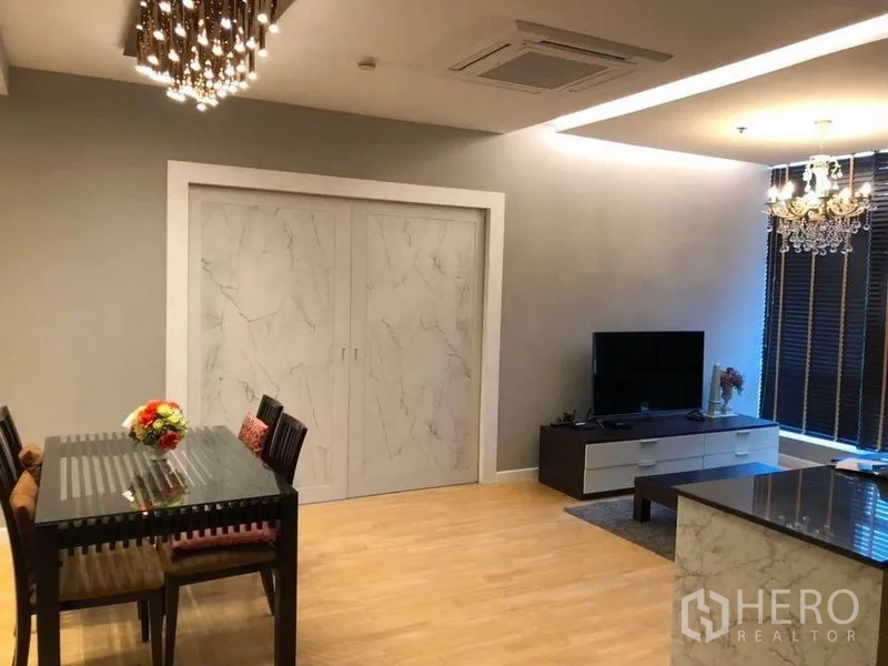 คอนโด ให้เช่าในKhlong San, Bangkok - พื้นที่รับประทานอาหารกับโคมไฟระย้าทันสมัย ตรงข้ามชั้นวางทีวีและบานเลื่อนลายหินอ่อน