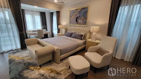 Detached House for rent or sale in Saphan Sung, Bangkok - Spacious master bedroom with upholstered bed, lounge seating, desk and layered drapes.