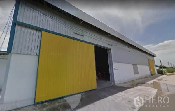 货栈 出租在Lat Krabang, Bangkok - 金属外墙仓库外观，黄色大推拉门，宽阔混凝土装卸区与高挑屋顶，位于曼谷Lat Krabang。