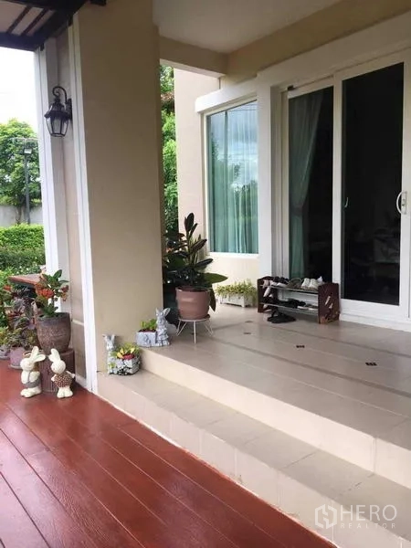 独立式住宅 出售在Bang Kruai, Nonthaburi - 入户有顶门廊，台阶、盆栽与推拉玻璃门。