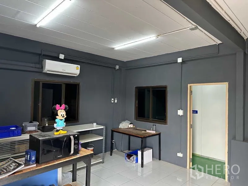 Factory for rent in Khlong Luang, Pathum Thani - Workshop or preparation room with tiled floor, split-type AC and worktables.