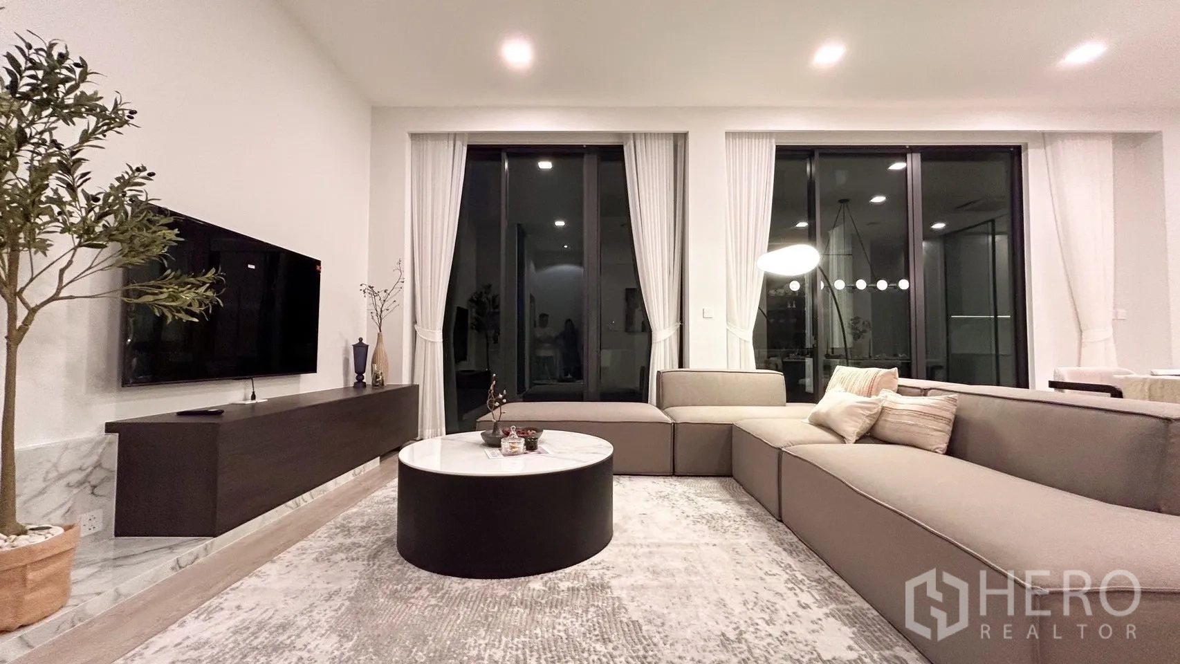 独立式住宅 出租在Saphan Sung, Bangkok - 现代客厅，转角沙发、电视墙和大推拉门。