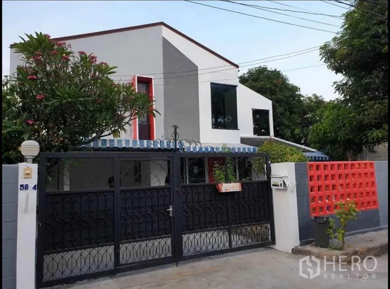 บ้าน ให้เช่าในLat Phrao, Bangkok - หน้าบ้านติดถนน มีกำแพงและประตูรั้วเหล็กสีดำ กับอาคารสองชั้นสไตล์โมเดิร์น