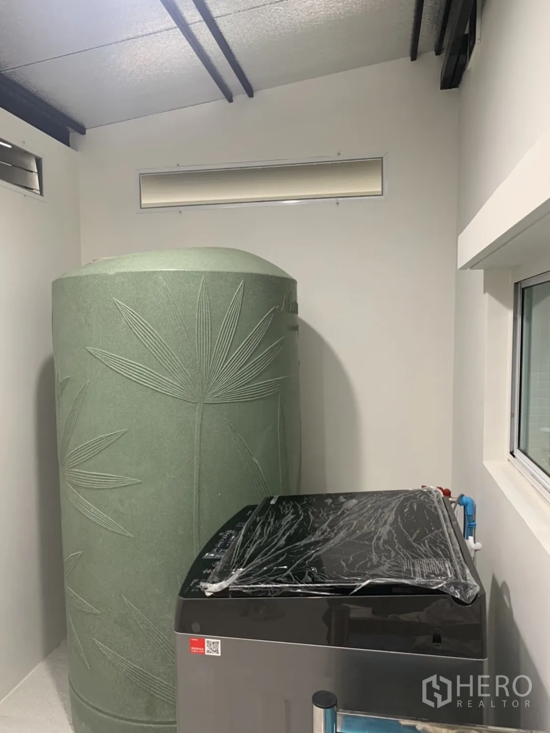 联排别墅 for rent in Bang Kapi, Bangkok - 生活阳台设大型绿色蓄水罐和上开式洗衣机。