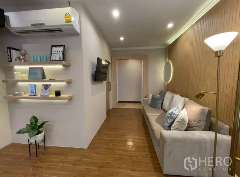 พื้นที่ขายปลีก ให้เช่า - มุมนั่งรอพร้อมโซฟายาว ชั้นวางลอย และผนังลายไม้